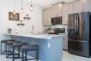 A modern kitchen with a central island, bar stools, stainless steel appliances, and pendant lighting. - SL2964PS - Luxurious 5Bdrooms Villa with Priv Pool (Kissimmee)