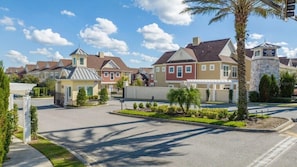 A residential area with houses, a gated entrance, and a sign for a vacation home. - SR7512SC - Sunny Villa Near Disney (Kissimmee)