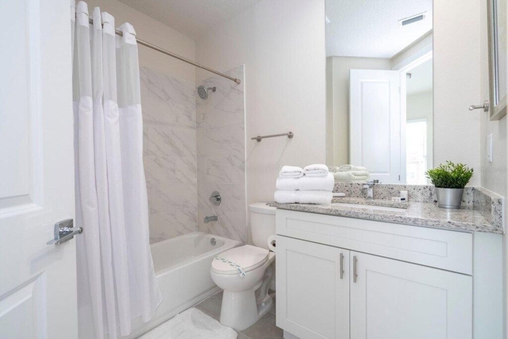 Een moderne badkamer met douche, toilet en wastafel.