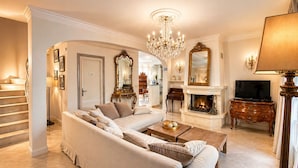 A living room with a sofa, a fireplace, a television, and a chandelier. -  Super Cannes villa D Aurus (Vallauris)