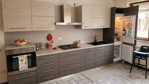 Uma cozinha moderna com forno embutido, fogão a gás e geladeira.