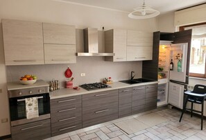 Eine moderne Küche mit Einbauofen, Gasherd und Kühlschrank.