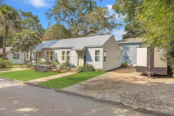 A single-story house with a front porch, a small lawn, and a paved driveway.