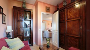 Uma sala de estar com um sofá vermelho, uma mesa de centro de madeira e uma estante de livros.