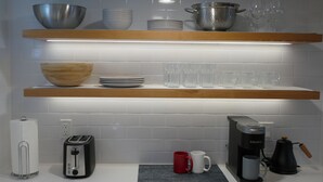 Ett kök med en brödrost, en kaffebryggare och en skål på bänkskivan.