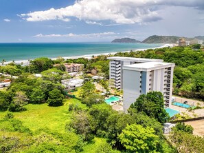 A coastal hotel with multiple floors, a swimming pool, and a beach view. - Beautiful, spacious 4-bedroom Penthouse, where luxury meets comfort. (Jaco)