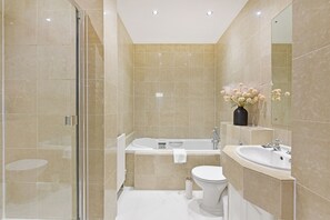 Une salle de bain moderne équipée d’une douche, de toilettes, d’une baignoire et d’un lavabo.