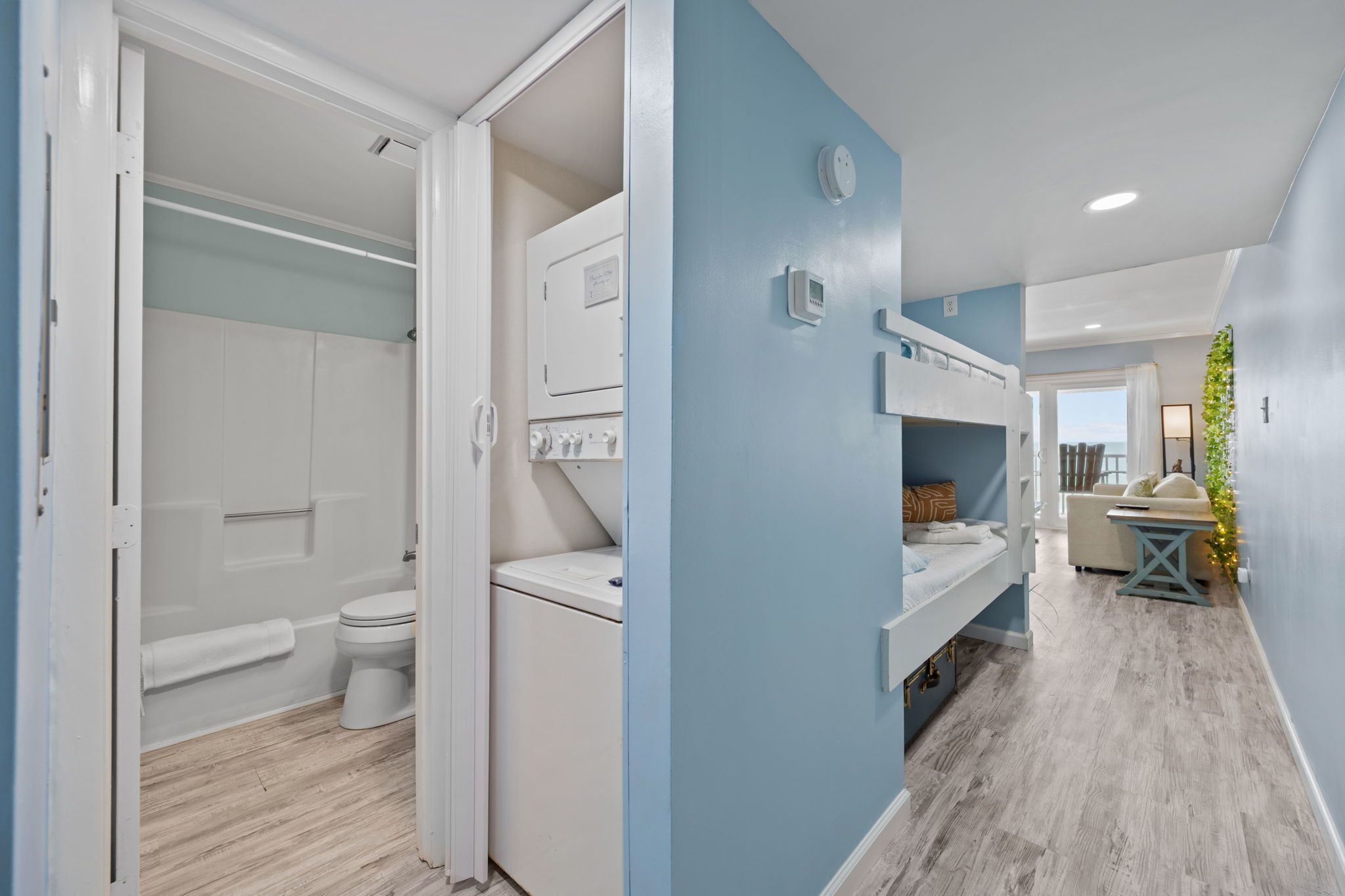Une salle de bain moderne équipée de toilettes, d’un lave-linge et d’armoires encastrées.