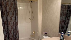 Ein Badezimmer mit Badewanne, Toilette, Waschbecken und Duschvorhang.