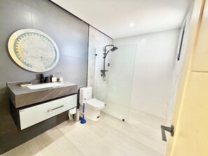 Un bagno moderno con lavabo in marmo, un water e una cabina doccia in vetro.