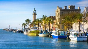 A coastal marina with boats docked, a lighthouse, and historic buildings. - 🌞🪸 Le Corail 🪸 - Apartment 3 bedrooms 6 people - 🦩 Le Grau Du Roi 🦩🌞 (Le Grau-du-Roi)