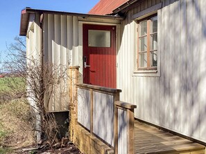 A wooden building with a red door and a small window. - 4 Star Holiday Home in Genarp (Hjarnarp)