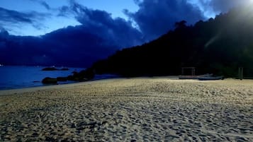 På stranden, vit sandstrand och parasoller