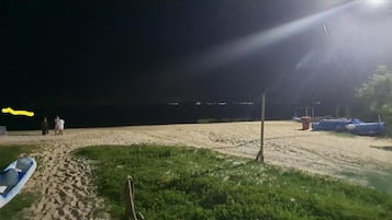 A la platja, platja de sorra blanca i para-sols per a la platja