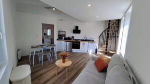 Um apartamento moderno com área de jantar, cozinha e escada.