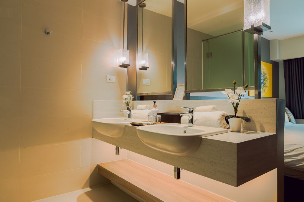 Un baño moderno con lavamanos dobles, un espejo grande y un mueble de tocador de madera.