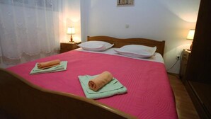 Ein Schlafzimmer mit einem Bett, zwei Nachttischen, einer Lampe und einem Gemälde an der Wand.