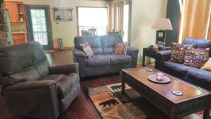 A living room with leather sofas, a coffee table, and a rug. - Creekside serenity in murphy (Murphy)