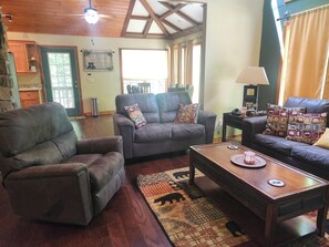 Ein Wohnzimmer mit Ledersofas, einem Couchtisch und einem Teppich.