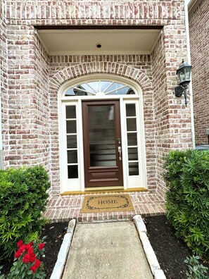 A brick house with a brown front door, a small porch, and a doormat with 'HOME' written on it. - Townhome Galleria/Uptown 15 min drive to FIFA World Cup, walk to top restaurants (Houston)