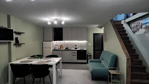 A modern interior with a dining area, kitchen, and staircase. - Sea Loft Varna - Entire 3-level 125sq.m. house in the top historical center (Varna)