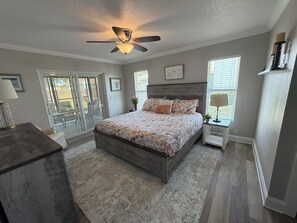 Ein Schlafzimmer mit Bett, Deckenventilator, Schreibtisch und Stuhl.