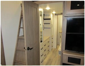 Ein Zimmer mit einer Holzlade, einem Schrank mit vielen Schubladen und einem Fernseher auf einem Tisch.