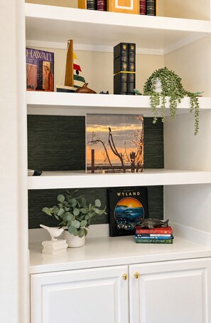 Ein Bücherregal mit Büchern, einem gerahmten Bild und Dekorationselementen.