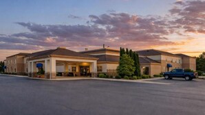A hotel with a covered entrance, a parking lot, and a blue pickup truck parked in front. - Best Western Davison Inn – Hotel in Davison, MI with Pool & Fitness Center (Davison)