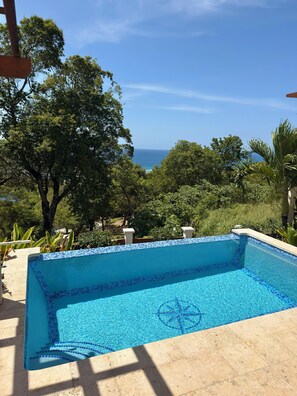 Una piscina al aire libre, sillones reclinables de piscina
