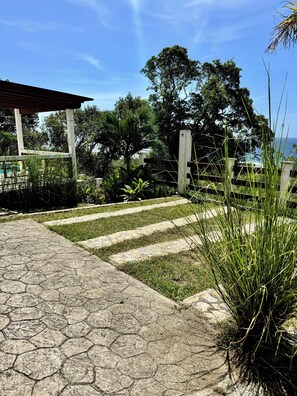 Un sendero pavimentado que conduce a una zona cubierta con vistas al océano.