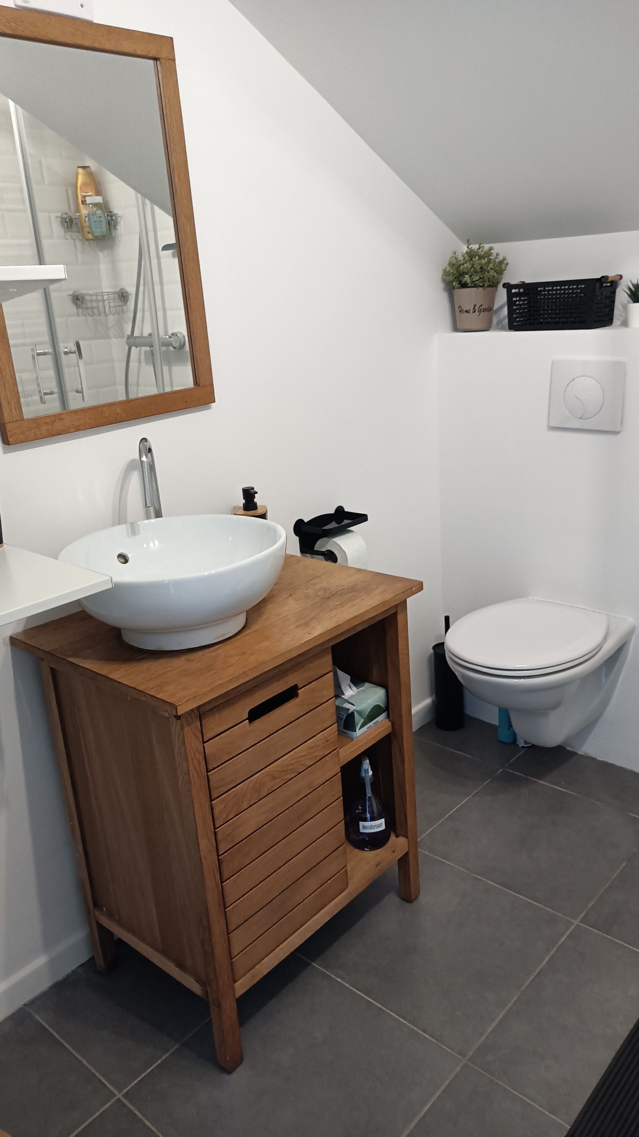 Ein Badezimmer mit Holzwaschtisch, weißem Waschbecken und Toilette.