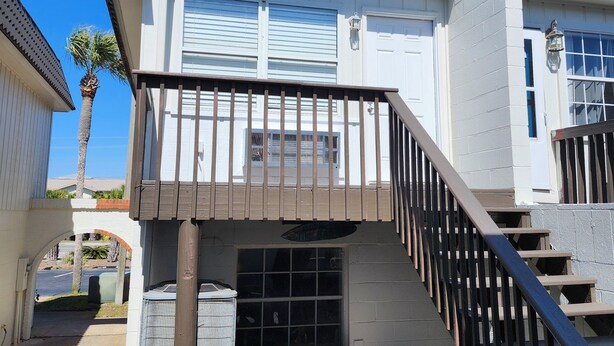 A two-story house with a balcony, a staircase, and a garage.