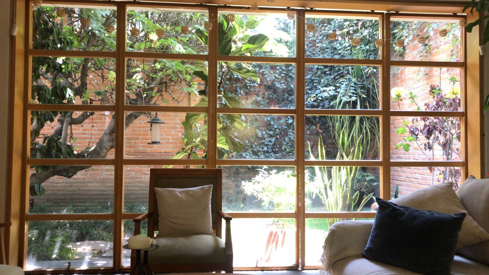 A room with a large window, a chair, and a couch.