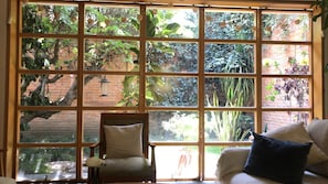 A room with a large window, a chair, and a couch. - Beautiful house in the heart of Coyoacan, 3BR, private garden and terrace (Ciudad de México)