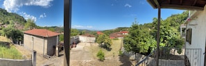 A residential area with houses, a stone wall, and a clear sky.