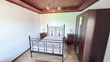 Une chambre à coucher avec un lit en métal, un plafond en bois et un petit tapis.