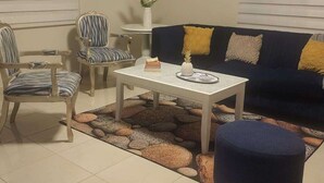 A living room with a sofa, chairs, a coffee table, and a decorative rug. - Villabasiliord Spacious house, quiet and safe place, 5 mins from the beach. (Puerto plata)