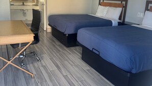 Una habitación de hotel con dos camas, un escritorio y una silla.