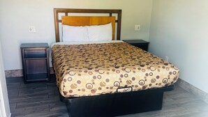 Un dormitorio con cama, mesita de noche y cómoda.