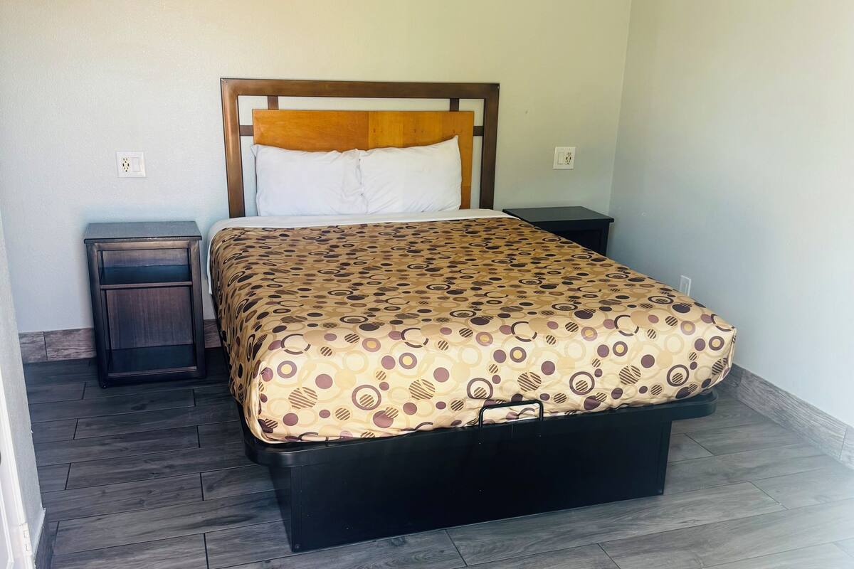 A bedroom with a bed, a nightstand, and a dresser.