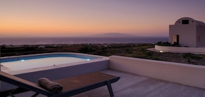 A rooftop pool with a view of the sea and distant hills at sunset. - Deluxe Villa with Plunge Pool in Oia (Oia)