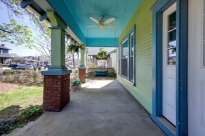 A covered porch with a ceiling fan, a brick column, and a bench. - 12 South Sanctuary | Azure Pool & Private Cabana (Nashville)