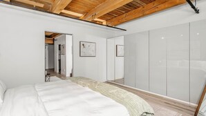 Um quarto com cama, espelho e guarda-roupa.