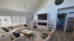 Amplia sala de estar con sofá, mesa de centro y televisor.