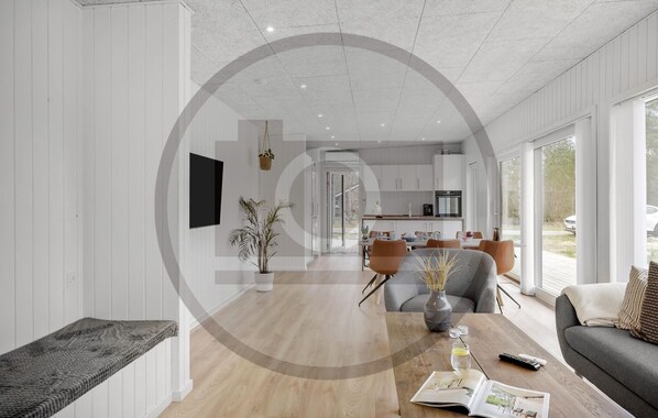A modern interior with a dining area, kitchen, and a large window.