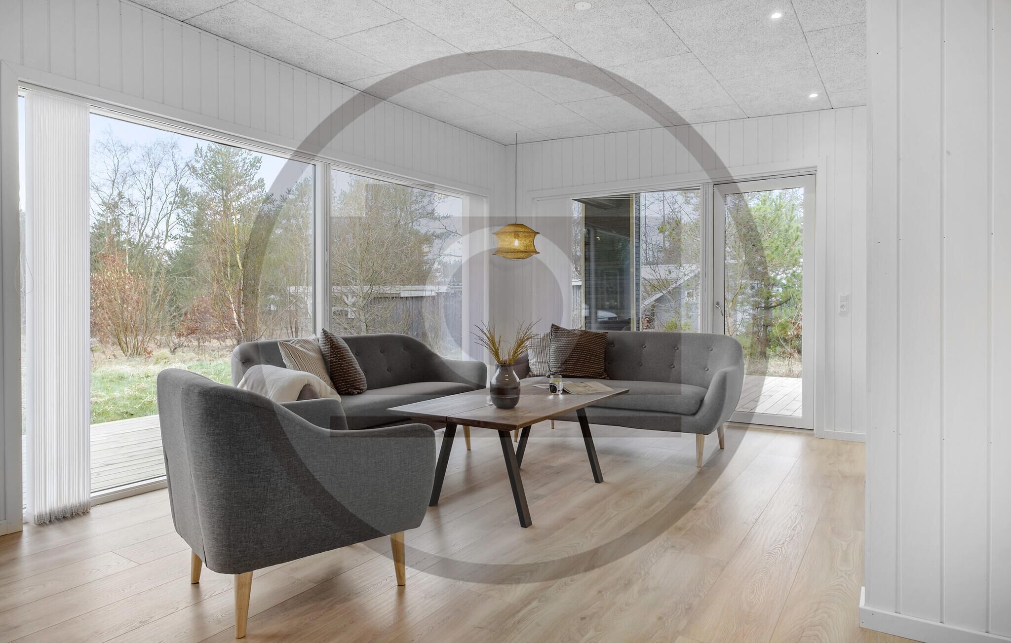 Una sala de estar moderna con un conjunto de sofás, una mesa de centro y una lámpara colgante.