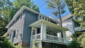 A two-story house with a front porch, brick foundation, and a small front yard. - University Hill Entire 5 BR House -  Walk to SU campus, Upstate Hospital (Syracuse)