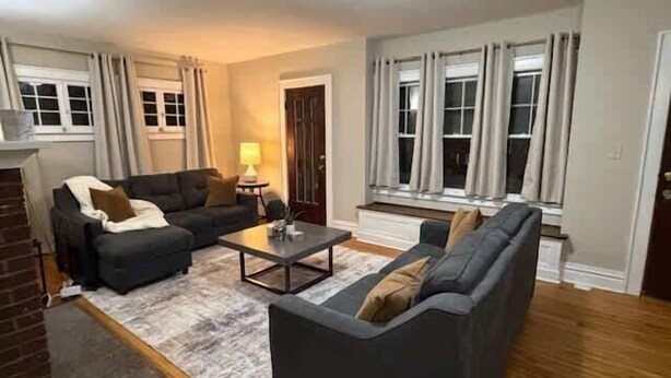 A living room with a fireplace, two sofas, a coffee table, and a lamp. - University Hill Entire 5 BR House -  Walk to SU campus, Upstate Hospital (Syracuse)