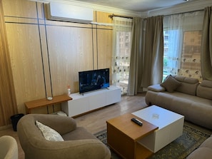 Ein Wohnzimmer mit Fernseher, Sofa und Couchtisch.